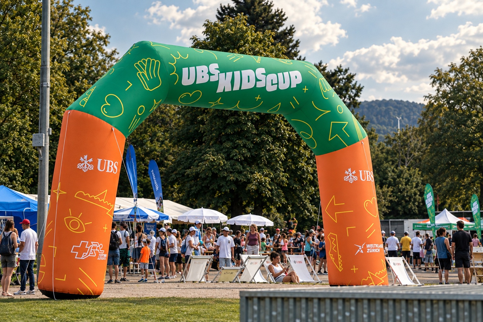 Orange-grüner UBS-Kids-Cup-Torbogen mit Menschen im Veranstaltungsbereich