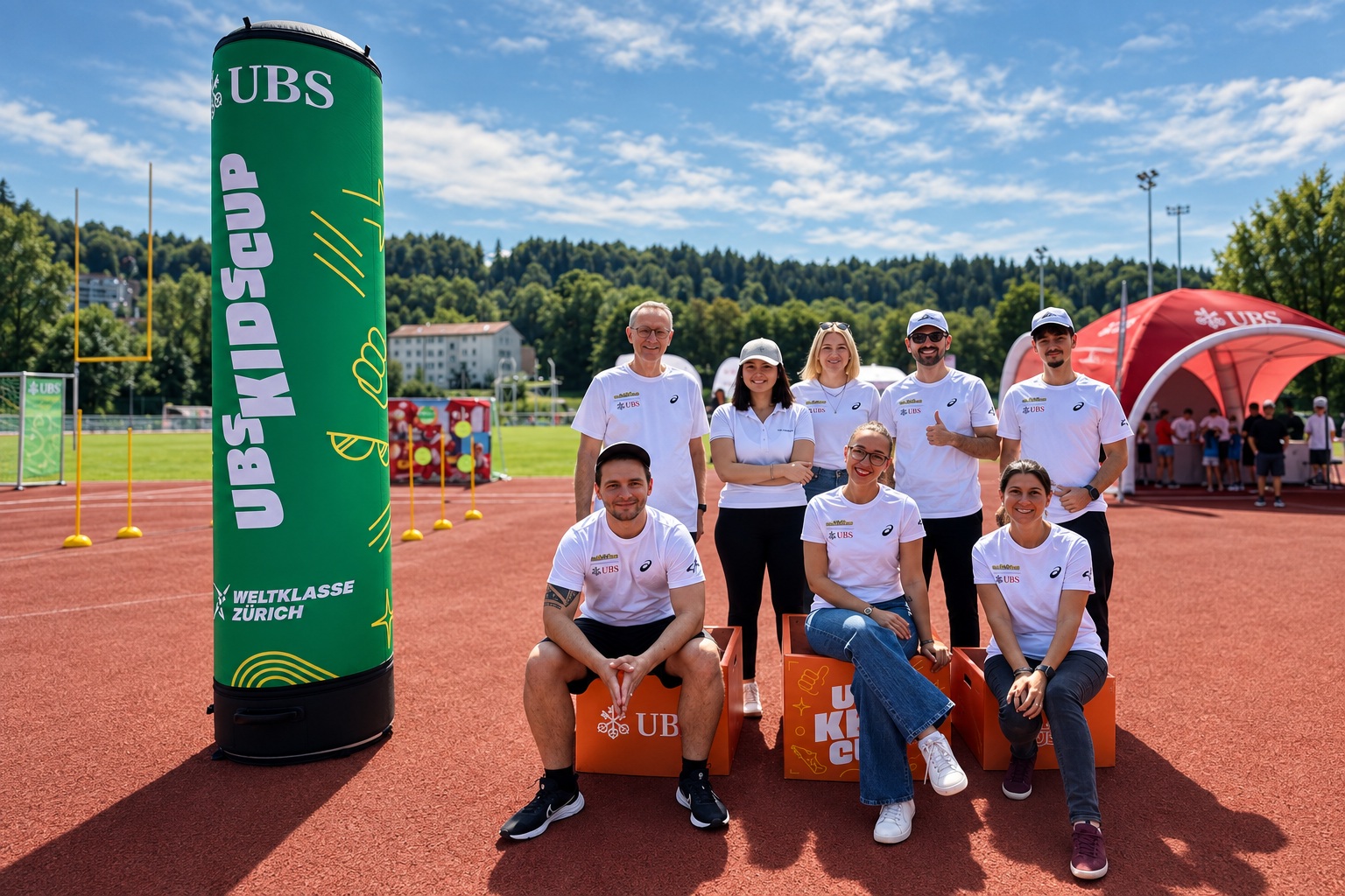 Team zwischen grüner Werbesäule und orangefarbenen Podestelementen