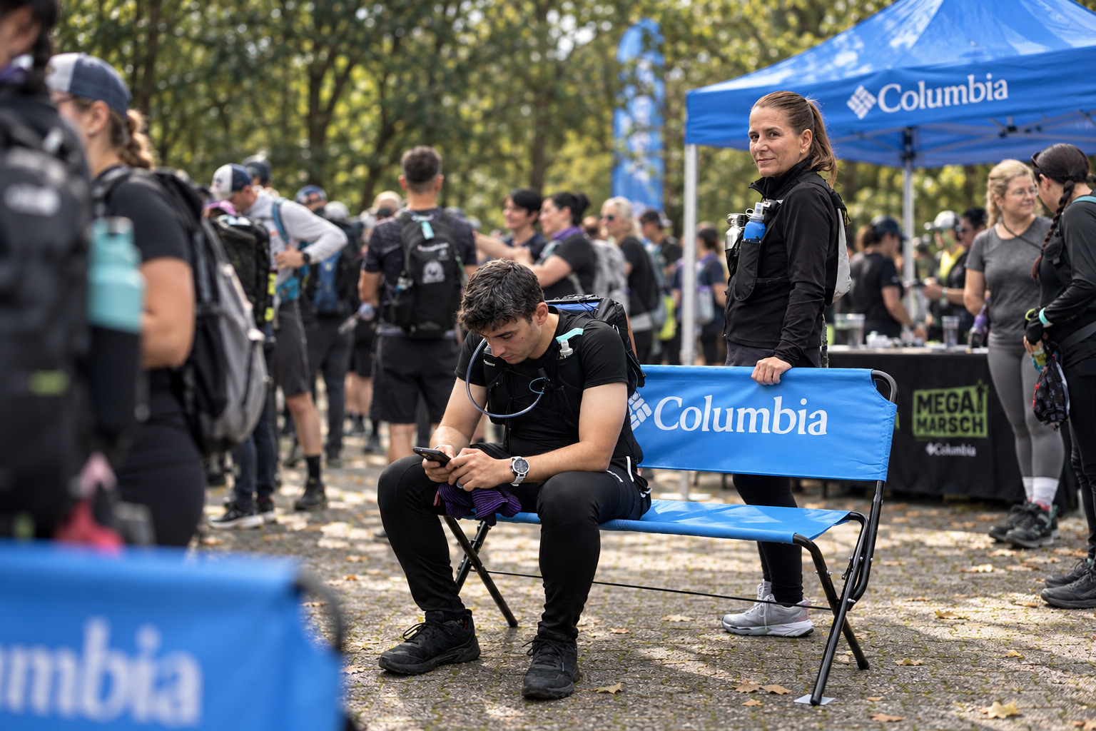 Teilnehmer auf einer blauen Columbia-Logobank beim Megamarsch Köln 2026