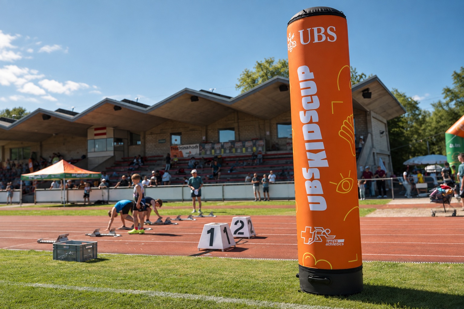 Orange UBS-Werbesäule mit Swiss-Athletics-Kennzeichnung neben der Laufbahn